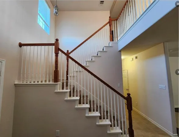 a view of staircase with wooden floor and white walls