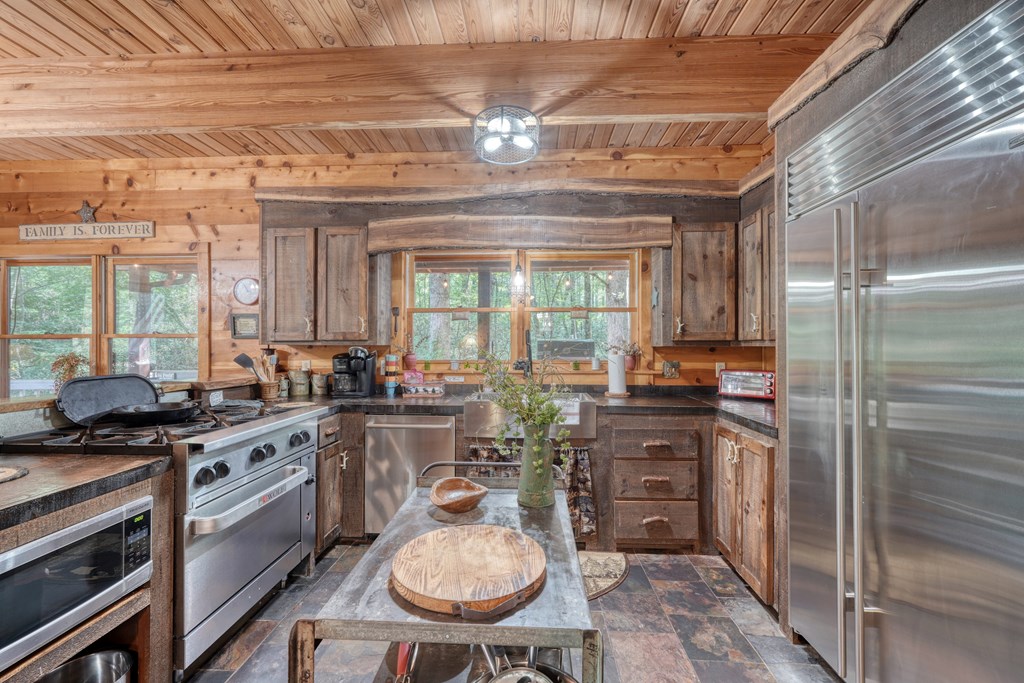 4836 Swallows Creek Road Hiawassee, GA 30546 - Photo 13 of 57 a kitchen with a stove a refrigerator and chairs