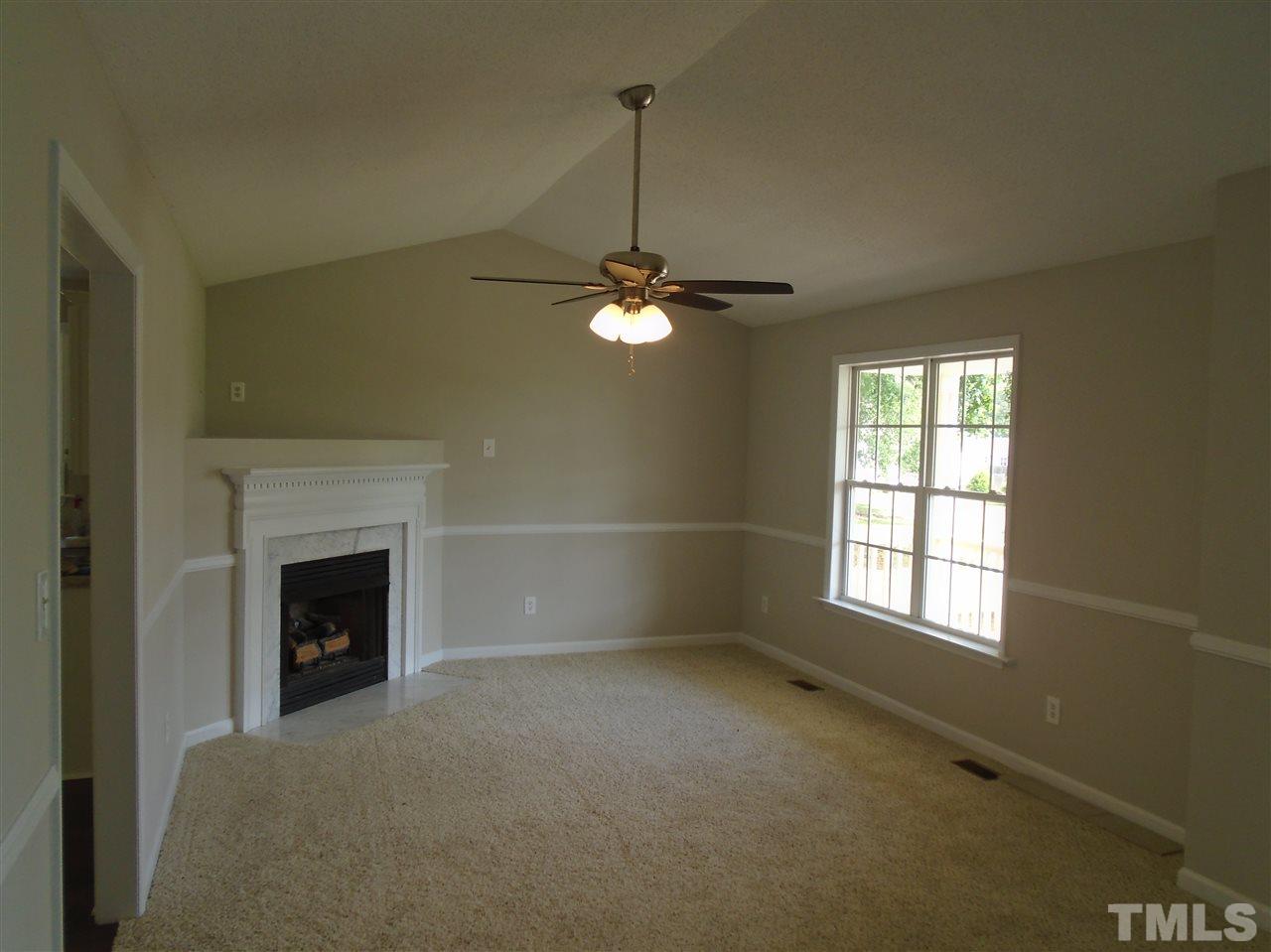 289 Wagner Road Willow Spring, NC 27592 - Photo 4 of 12 a living room with a fireplace and a window