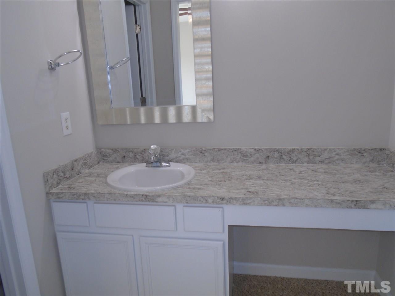 289 Wagner Road Willow Spring, NC 27592 - Photo 7 of 12 a bathroom with a granite countertop sink and a mirror
