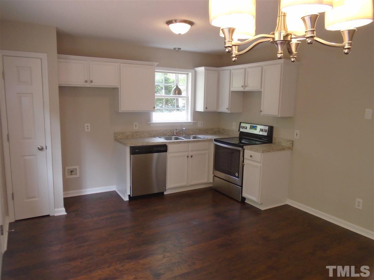 289 Wagner Road Willow Spring, NC 27592 - Photo 8 of 12 a kitchen with stainless steel appliances a sink a stove a refrigerator and wooden floor
