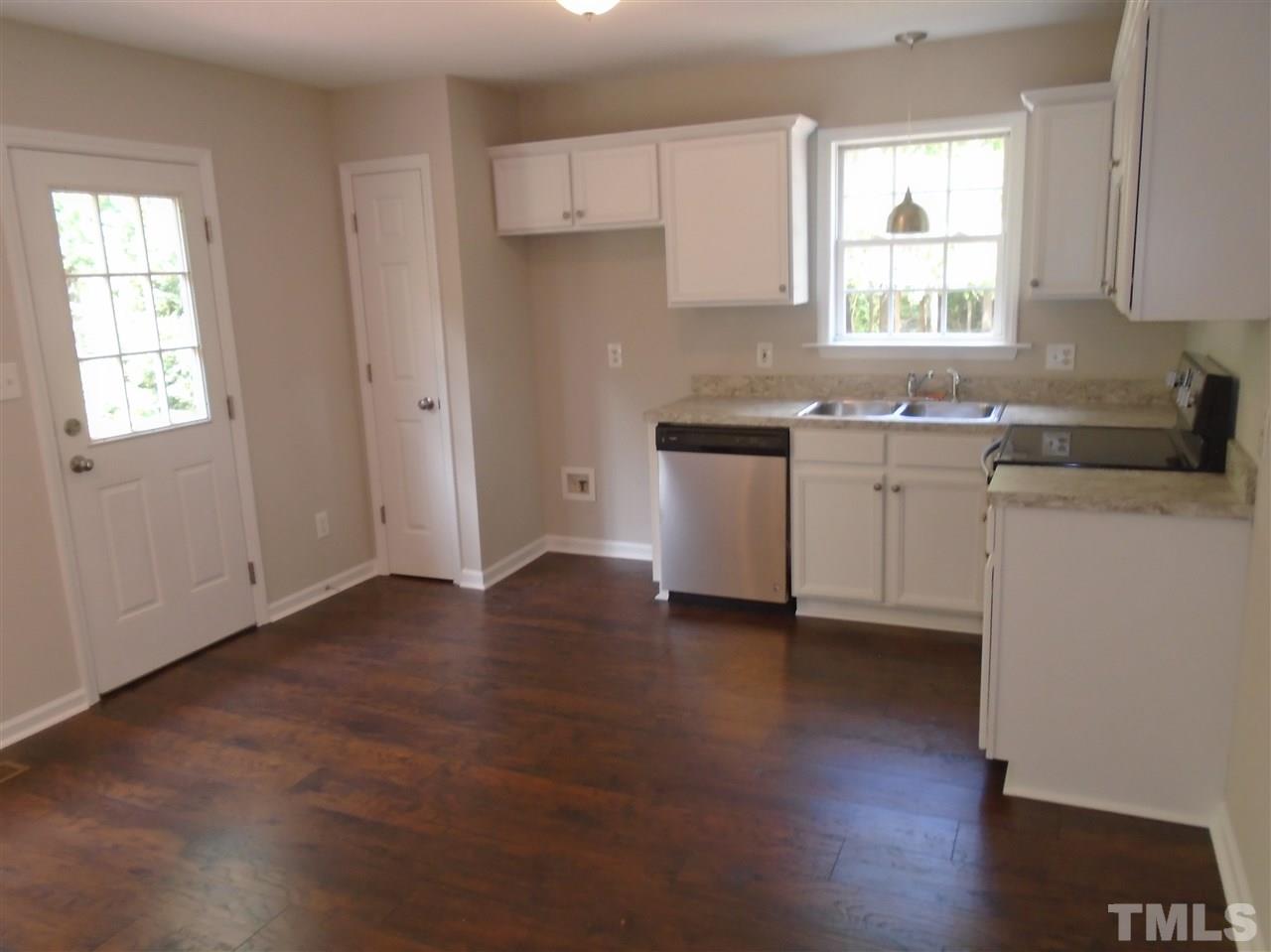 289 Wagner Road Willow Spring, NC 27592 - Photo 9 of 12 a kitchen with granite countertop a sink cabinets a window and a counter space