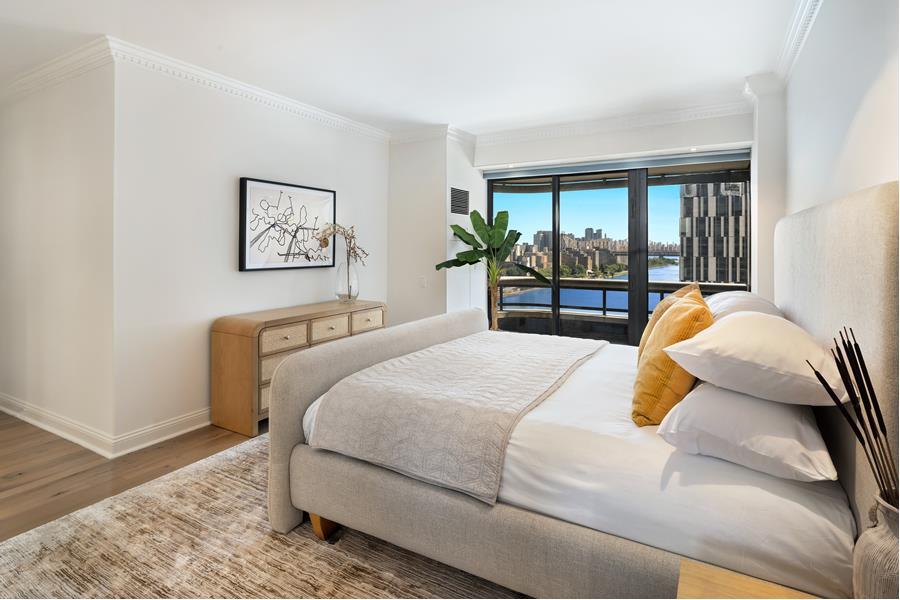 530 East 76th Street, Unit 21HJK Manhattan, NY 10021 - Photo 12 of 21 a bedroom with a bed and wooden floor