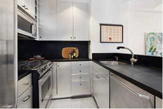 530 East 76th Street, Unit 21HJK Manhattan, NY 10021 - Photo 16 of 21 a kitchen with white cabinets and appliances