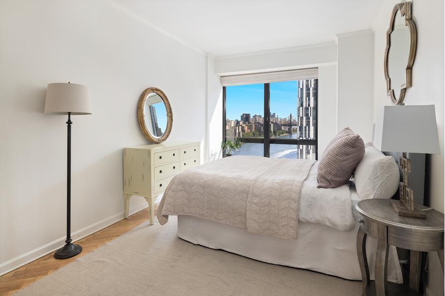 530 East 76th Street, Unit 21HJK Manhattan, NY 10021 - Photo 18 of 21 a bedroom with a bed a mirror and table