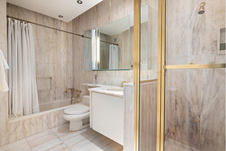 530 East 76th Street, Unit 21HJK Manhattan, NY 10021 - Photo 19 of 21 a bathroom with a toilet a sink and a shower