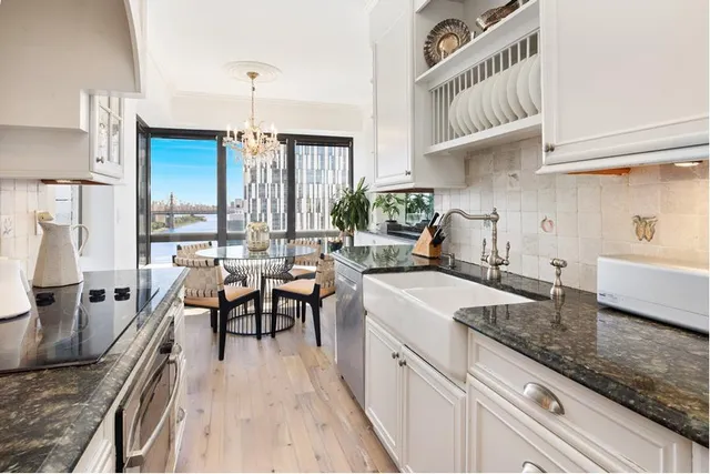 a kitchen with granite countertop a table chairs stove and cabinets
