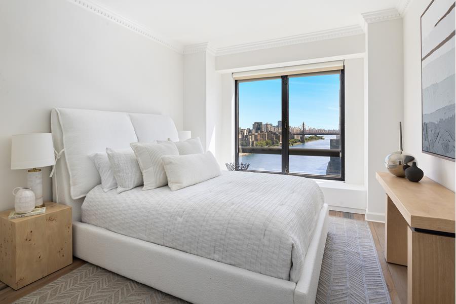 530 East 76th Street, Unit 21HJK Manhattan, NY 10021 - Photo 9 of 21 a bedroom with a bed and a large window
