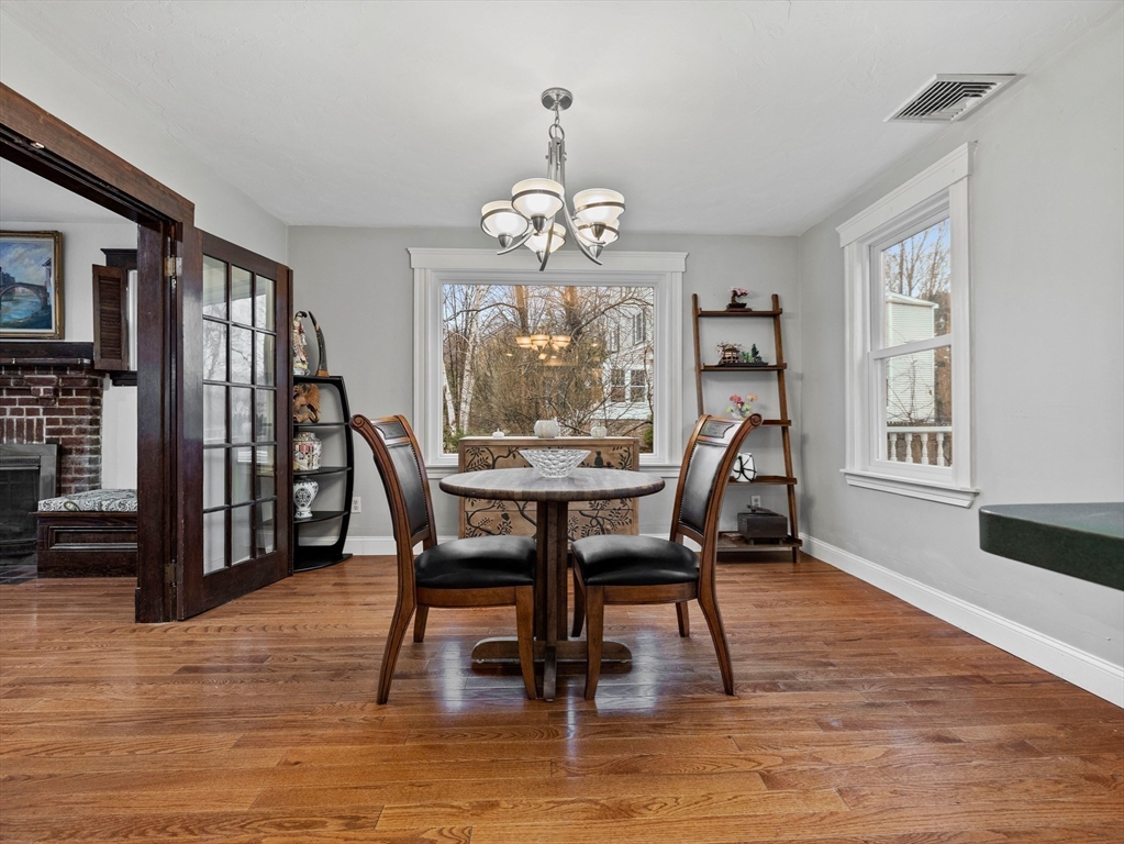 55 Kellogg Street Framingham, MA 01701 - Photo 8 of 42 a dining room with wooden floor a chandelier a glass table and chairs