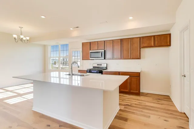 a large kitchen with stainless steel appliances granite countertop a stove a sink and a refrigerator