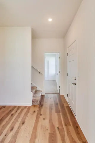 an empty room with wooden floor and window