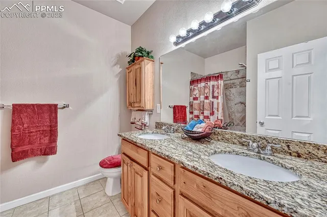 a bathroom with a granite countertop double vanity sink and a mirror