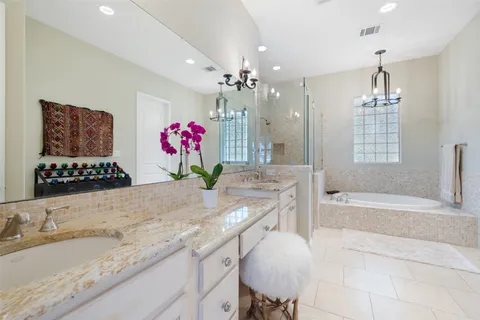 a bathroom with a granite countertop sink a large mirror and a bathtub
