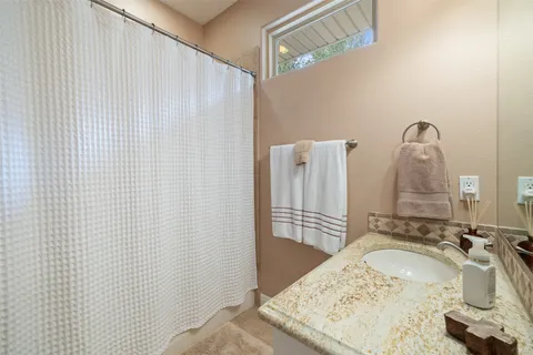 a bathroom with a granite countertop sink and a mirror
