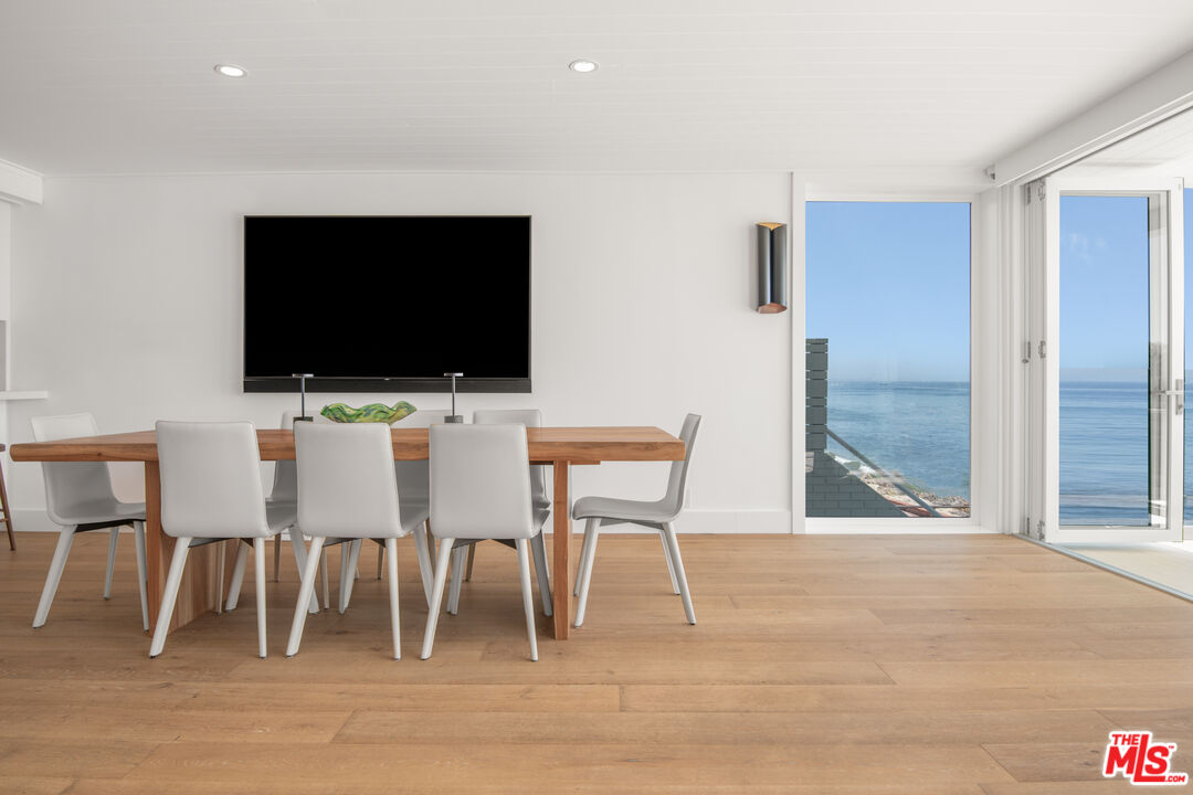 24134 Malibu Road Malibu, CA 90265 - Photo 6 of 39 a view of a livingroom with furniture a flat screen tv and wooden floor