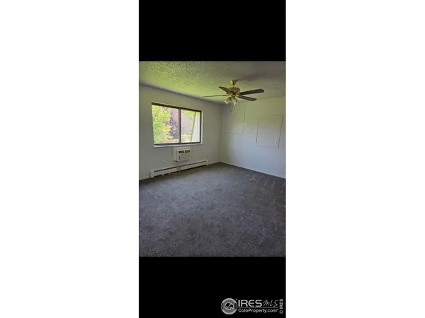 a view of a room with a window and hardwood floor