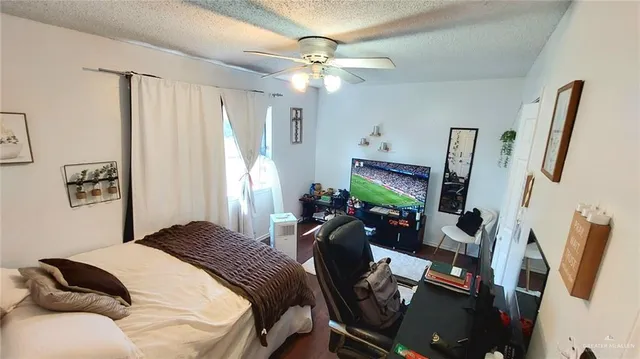 a bedroom with a bed gym equipment and a flat screen tv