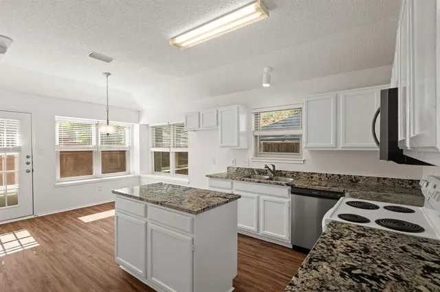 a kitchen with a stove sink and window