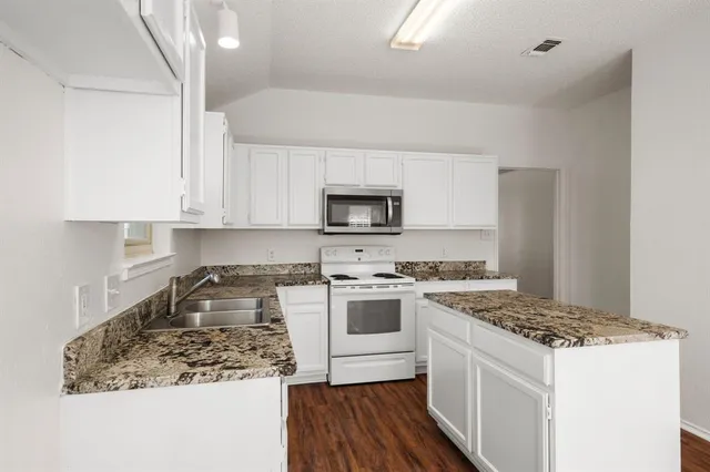 a kitchen with a sink stove and microwave