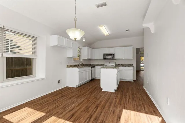 a view of a kitchen with a sink dishwasher and wooden floor