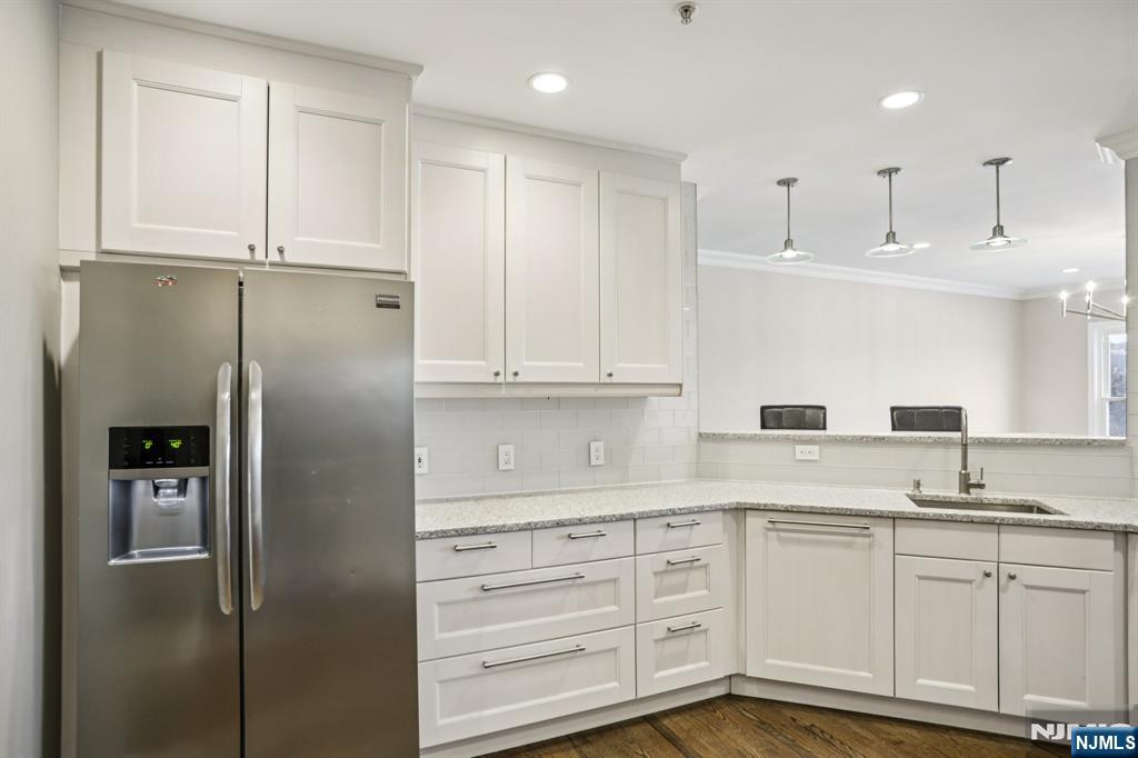 343 The Promenade, Unit 343 Edgewater, NJ 07020 - Photo 13 of 38 a kitchen with white cabinets and refrigerator
