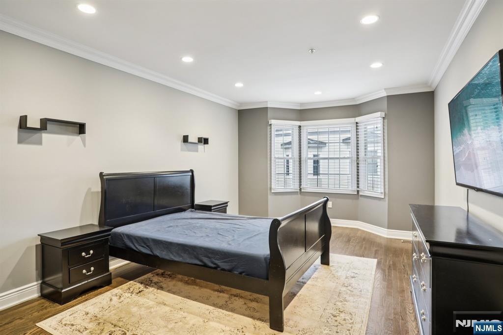 343 The Promenade, Unit 343 Edgewater, NJ 07020 - Photo 20 of 38 a bedroom with a bed and wooden floor