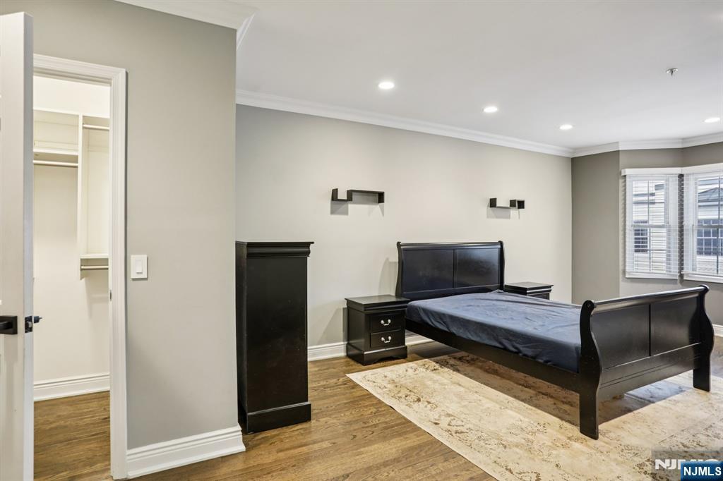 343 The Promenade, Unit 343 Edgewater, NJ 07020 - Photo 21 of 38 a bedroom with a bed and wooden floor