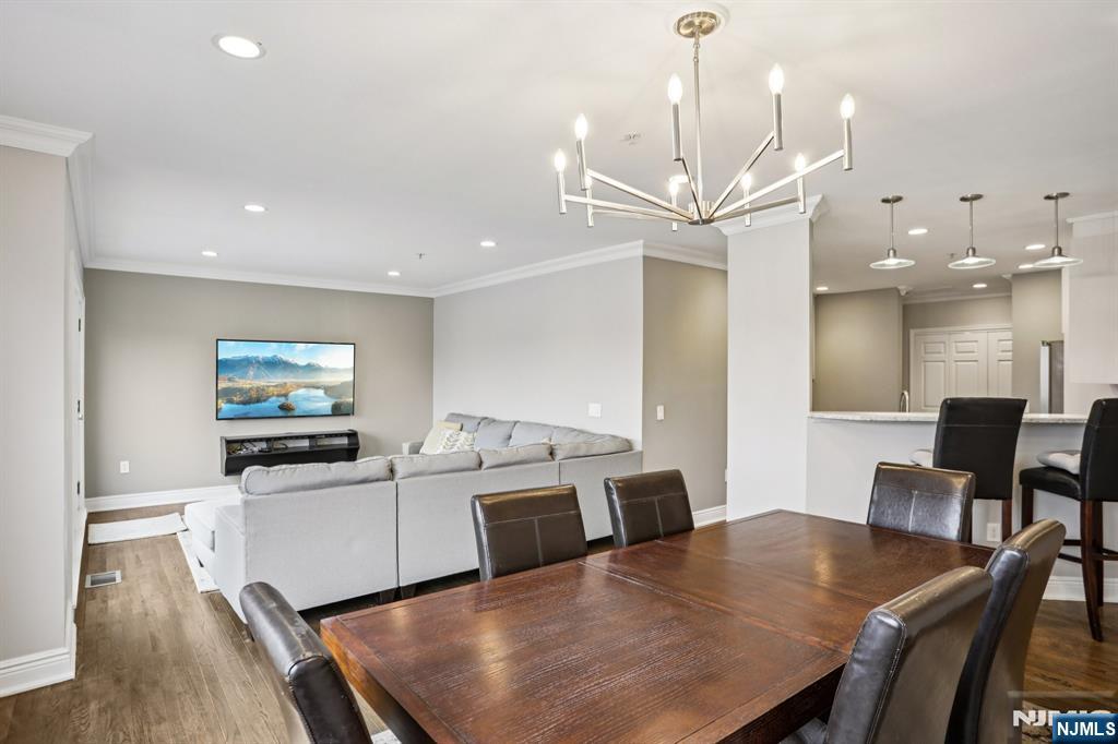 343 The Promenade, Unit 343 Edgewater, NJ 07020 - Photo 6 of 38 a view of a dining room with furniture and wooden floor