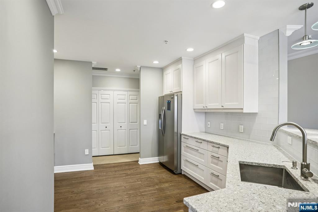 343 The Promenade, Unit 343 Edgewater, NJ 07020 - Photo 10 of 38 a kitchen with stainless steel appliances granite countertop a refrigerator and a sink