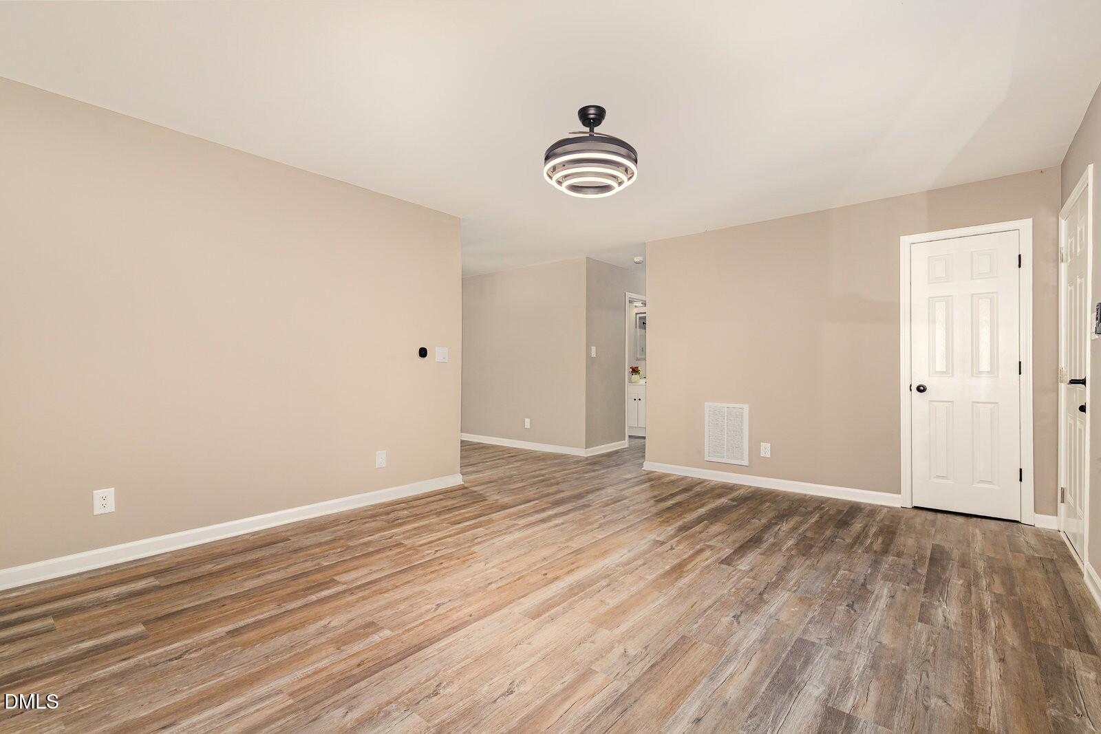 3204 Friar Tuck Road Raleigh, NC 27610 - Photo 5 of 26 an empty room with wooden floor and windows