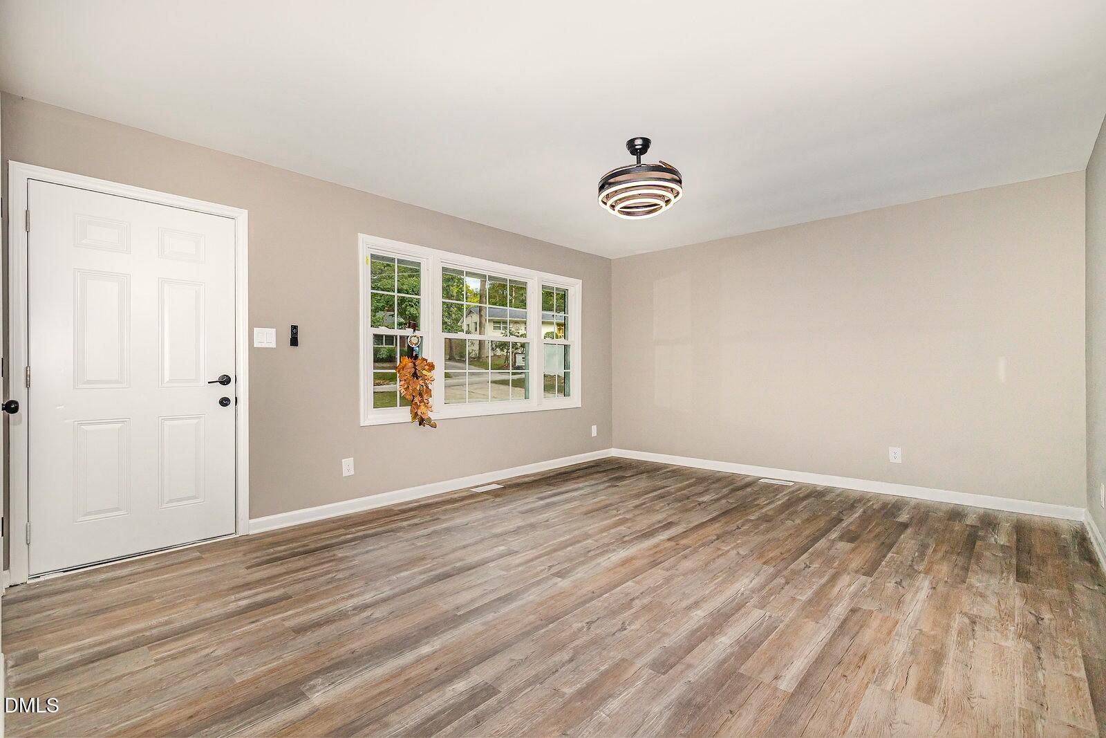 3204 Friar Tuck Road Raleigh, NC 27610 - Photo 6 of 26 wooden floor in an empty room with a window