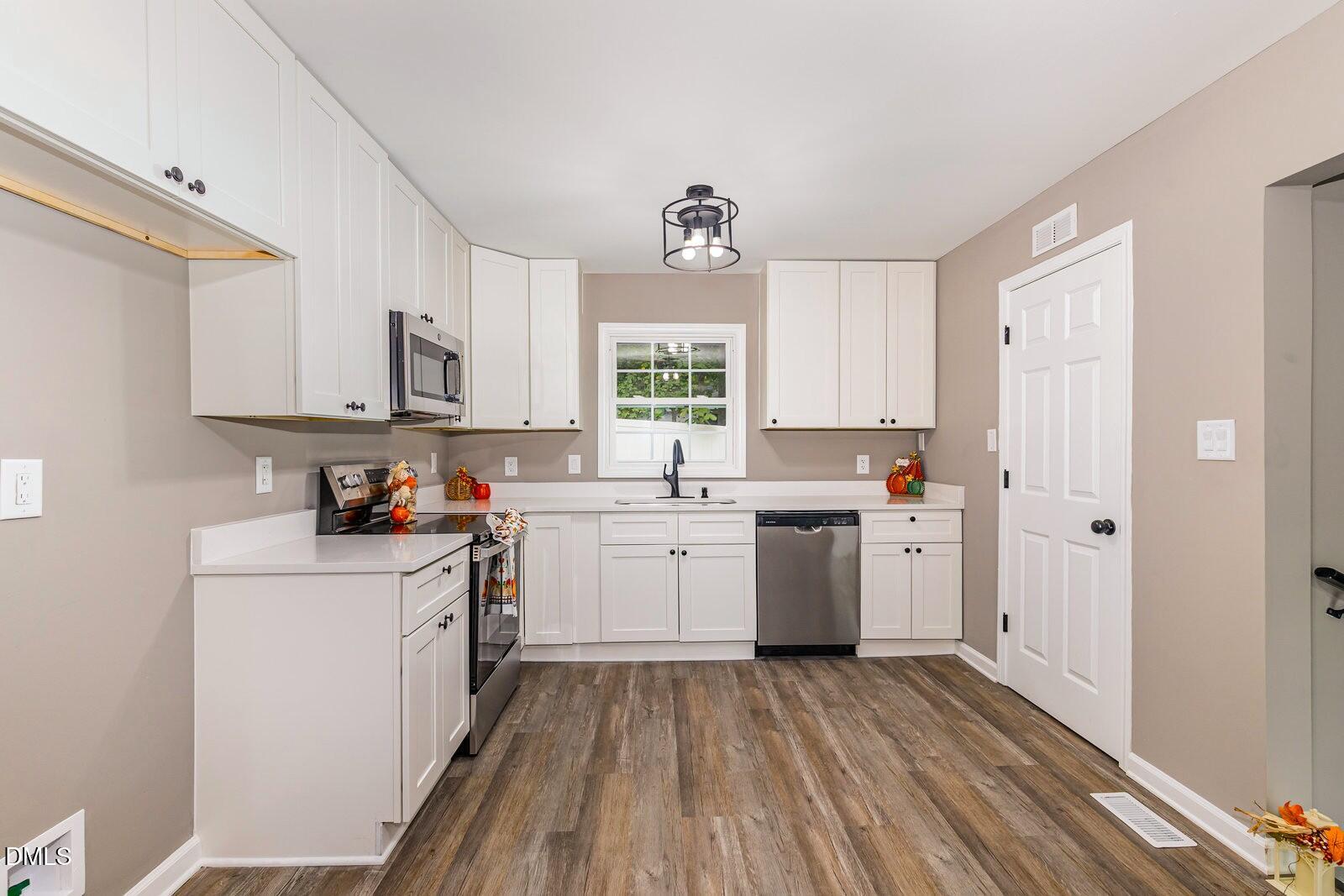 3204 Friar Tuck Road Raleigh, NC 27610 - Photo 8 of 26 a kitchen with sink a microwave and cabinets
