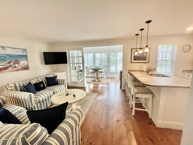 a living room with furniture a fireplace and a dining table with wooden floor