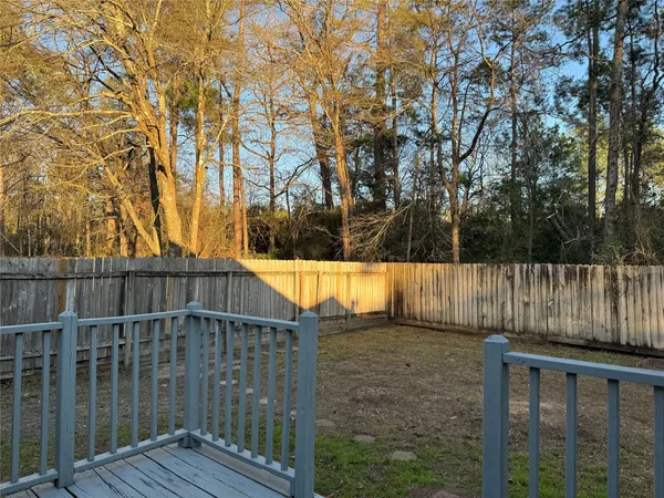 a view of backyard with green space and wooden fence
