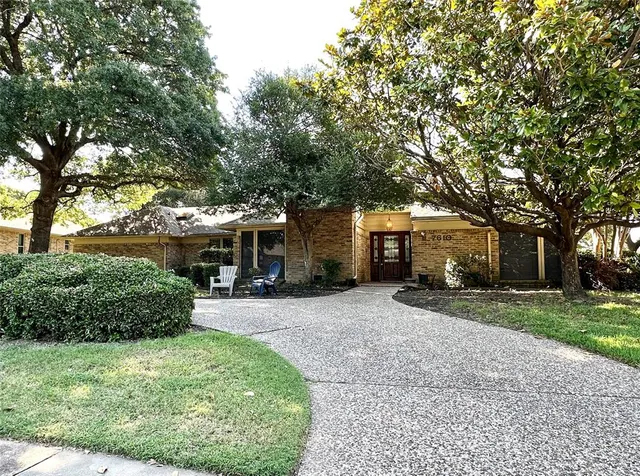 a front view of a house with a yard and trees