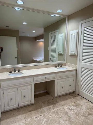a bathroom with double sink and a mirror