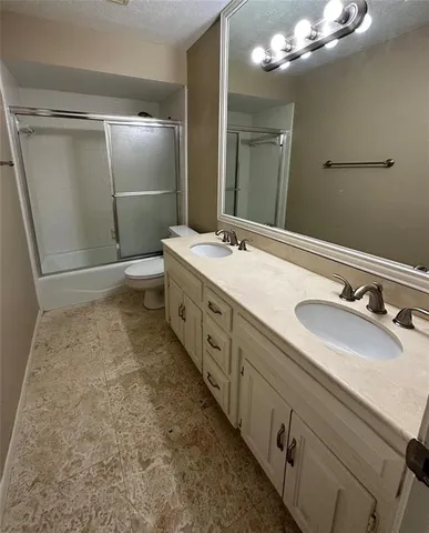 a bathroom with a double vanity sink mirror and shower