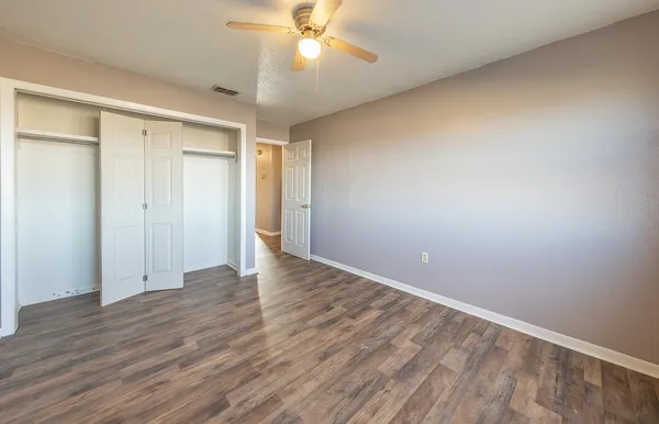 a view of an empty room with wooden floor