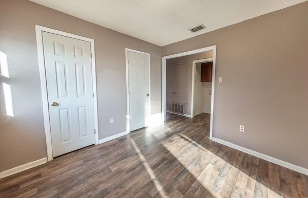 a view of a bedroom with wooden floor and bathroom