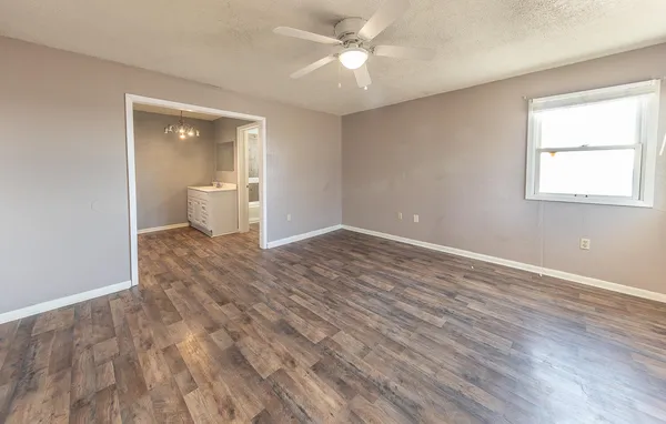 a view of a room with wooden floor and a ceiling fan