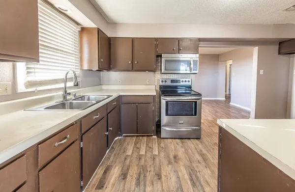 a kitchen with a sink stove and cabinets