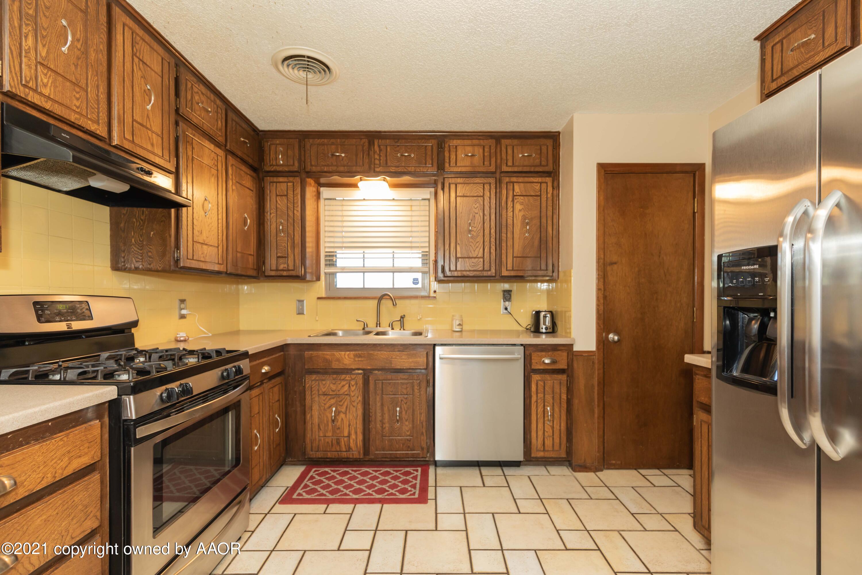 8100 Santa Fe Trail Amarillo, TX 79110 - Photo 10 of 35 a kitchen with a sink a refrigerator and cabinets