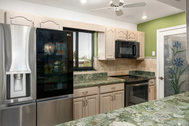 a kitchen with stainless steel appliances granite countertop a refrigerator a stove top oven a sink and dishwasher