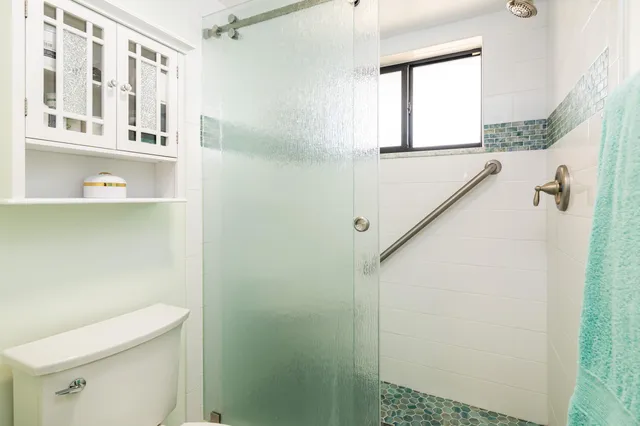 a bathroom with a shower a toilet and a sink