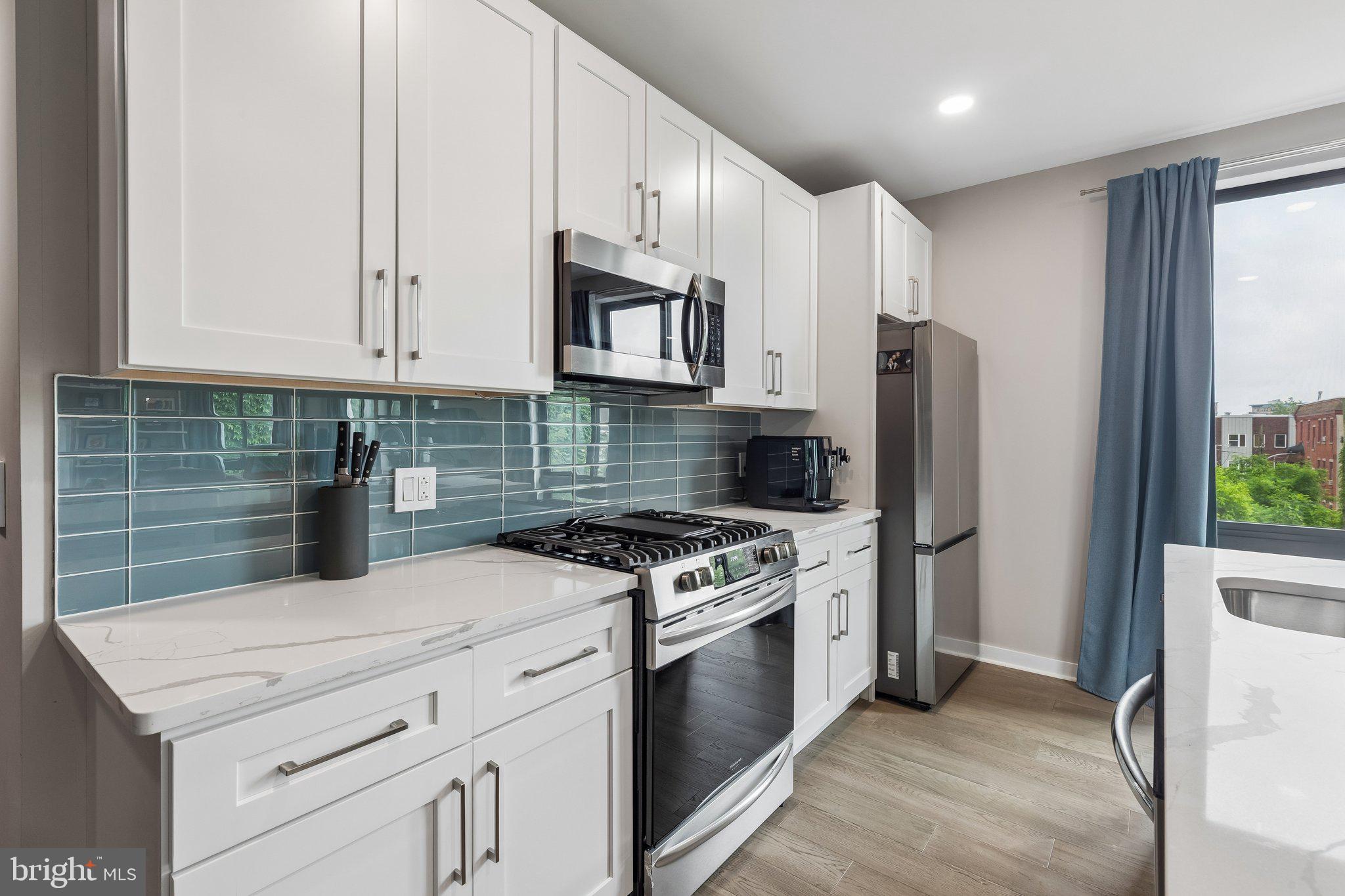 1648-50 Ridge Avenue, Unit 302 Philadelphia, PA 19130 - Photo 12 of 38 a kitchen with stainless steel appliances granite countertop a stove a refrigerator and a white cabinets