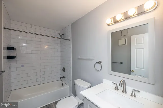 a bathroom with a sink mirror toilet and bathtub