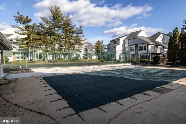 a front view of a building with streets and trees