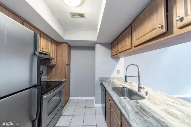 a kitchen with granite countertop a sink stainless steel appliances and cabinets