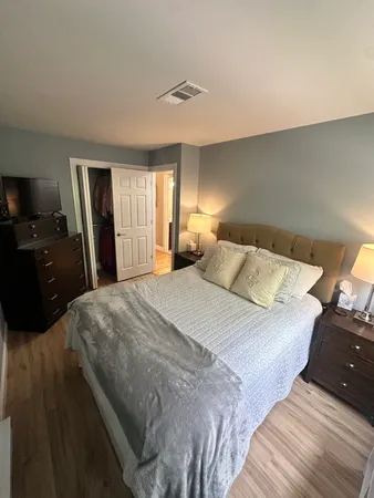 a bedroom with a bed and wooden floor