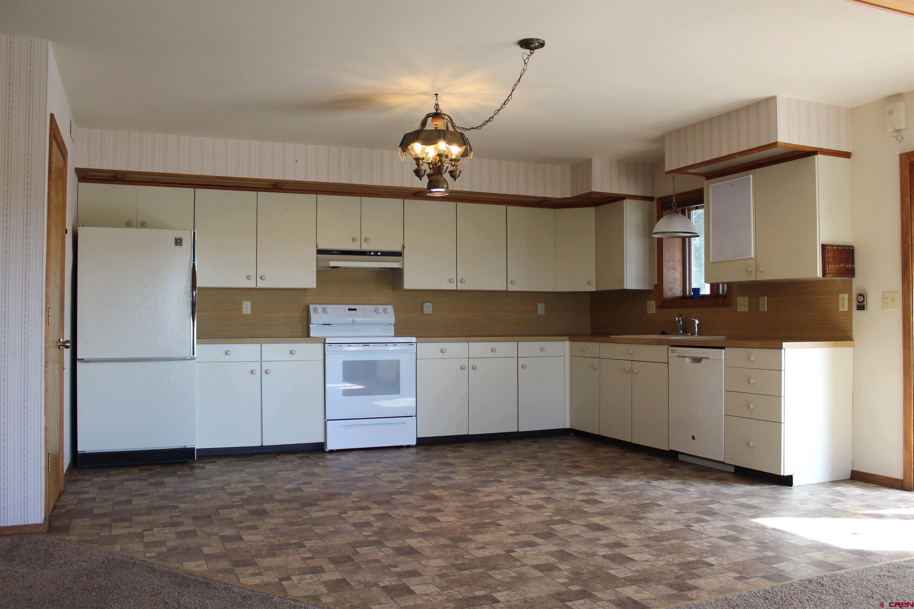 16754 Bull Mesa Road Cedaredge, CO 81413 - Photo 11 of 35 a kitchen with granite countertop white cabinets and stainless steel appliances